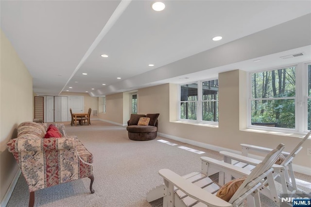 carpeted living area with recessed lighting, baseboards, visible vents, and plenty of natural light
