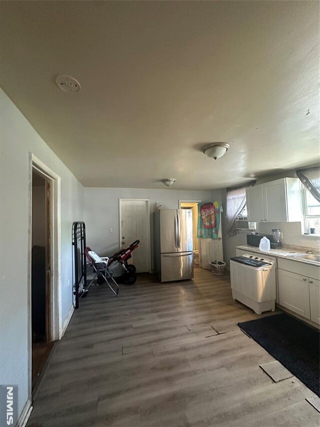 kitchen featuring freestanding refrigerator, wood finished floors, stove, light countertops, and dishwasher