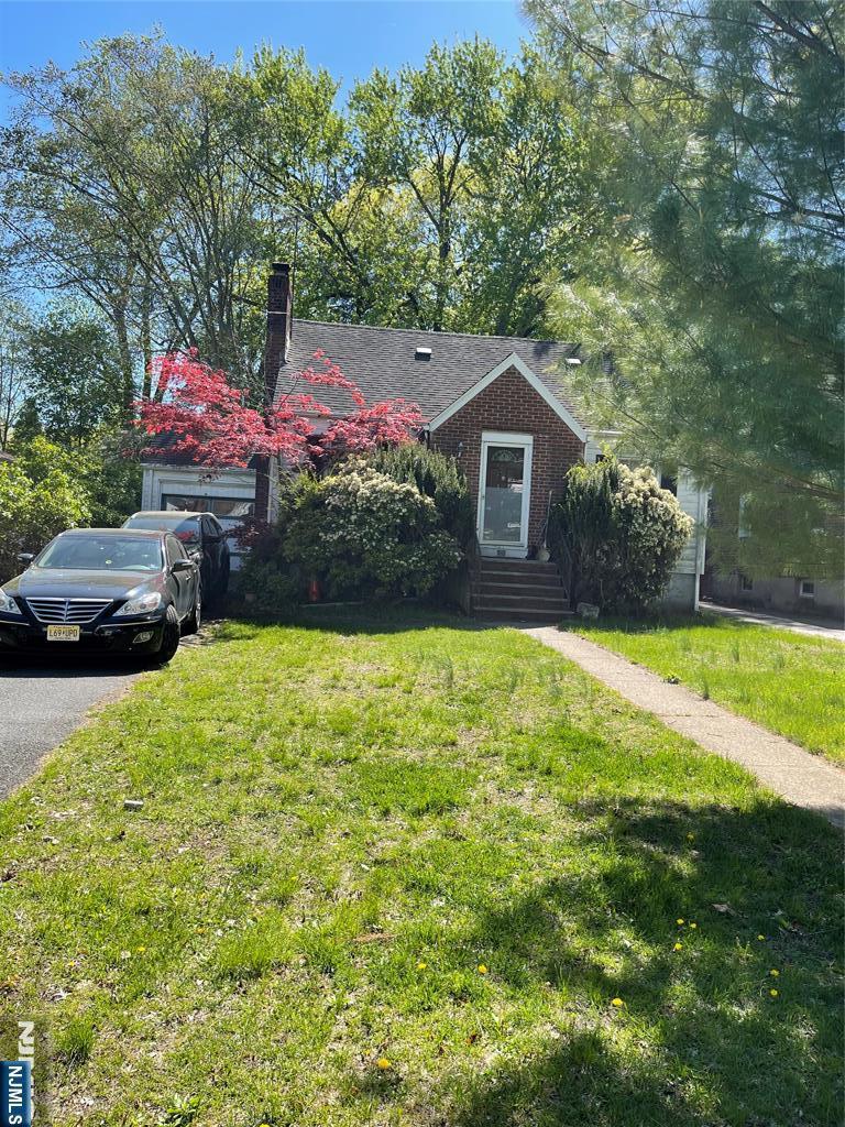 view of front facade featuring a front lawn and a chimney
