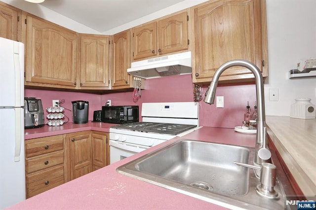kitchen featuring light countertops, a sink, under cabinet range hood, and white appliances