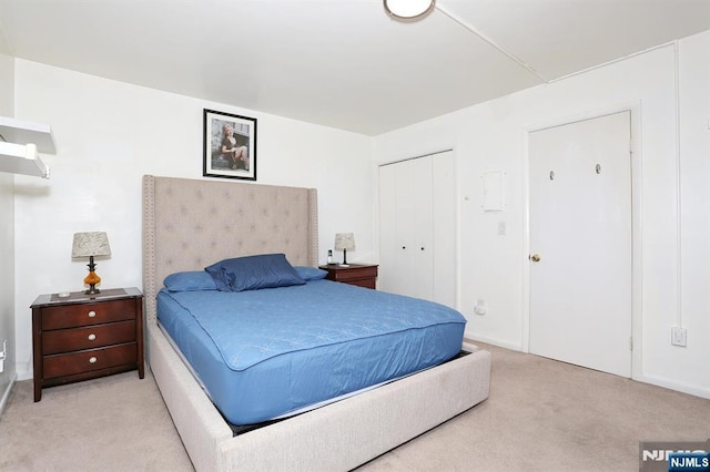 bedroom featuring a closet and light colored carpet