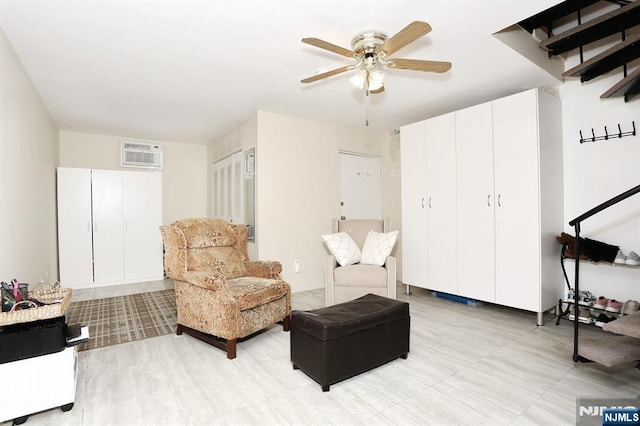 living area featuring a ceiling fan and an AC wall unit