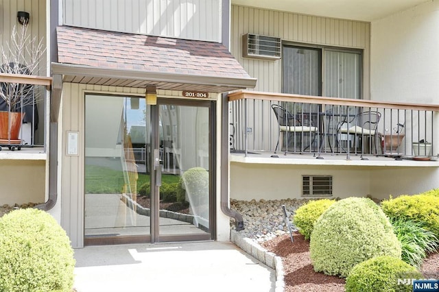 property entrance featuring roof with shingles