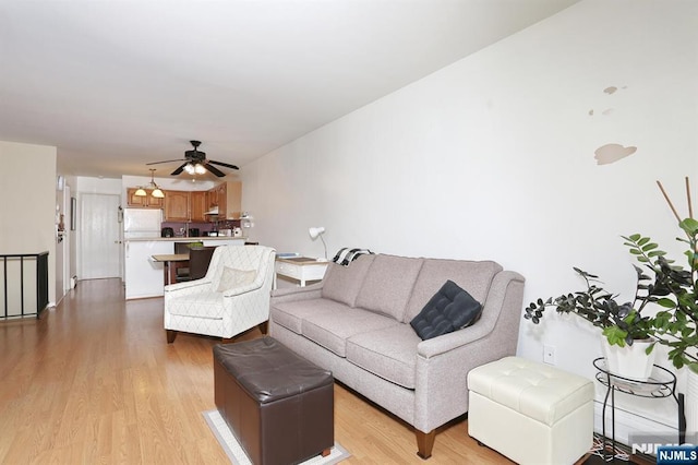 living room with a ceiling fan and light wood-style flooring
