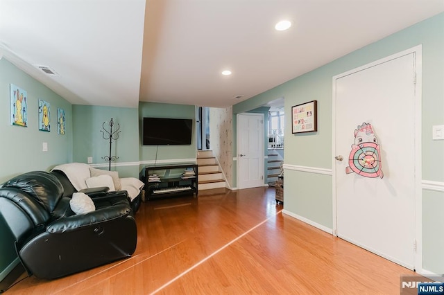 living room with recessed lighting, wood finished floors, and stairs