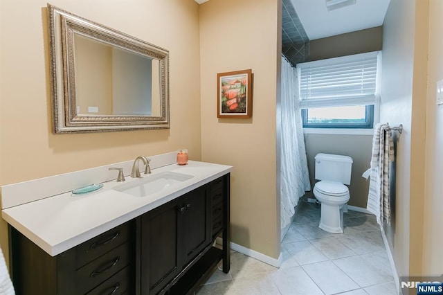 bathroom with vanity, baseboards, toilet, and tile patterned flooring