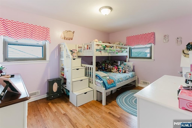 bedroom with light wood-style floors and visible vents