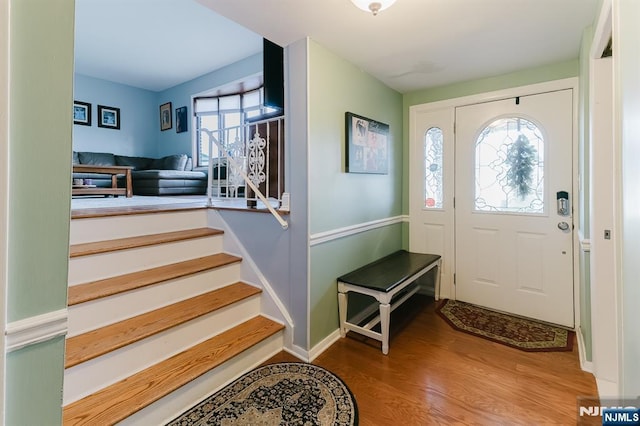 entryway featuring baseboards, stairs, and wood finished floors