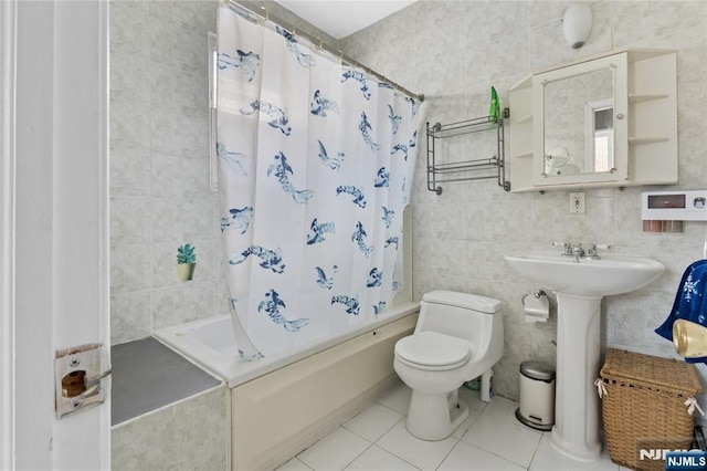 bathroom featuring tile patterned flooring, shower / bath combo, toilet, and tile walls