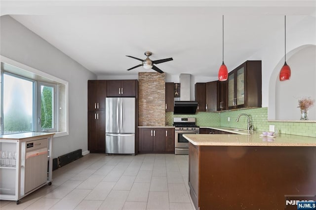 kitchen featuring a sink, wall chimney exhaust hood, decorative backsplash, and stainless steel appliances