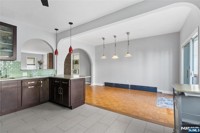 kitchen with plenty of natural light, arched walkways, a sink, and light countertops
