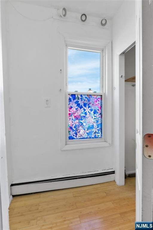 interior space featuring baseboard heating and wood finished floors