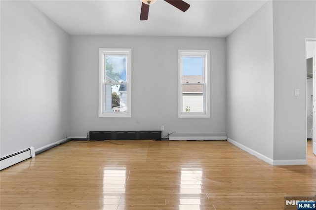 unfurnished room with light wood-style floors, baseboards, a ceiling fan, and a baseboard heating unit