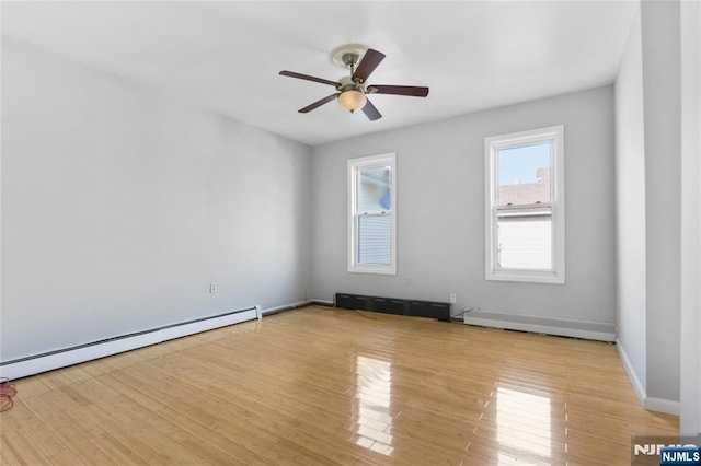 empty room featuring baseboards, a baseboard radiator, a ceiling fan, and wood finished floors