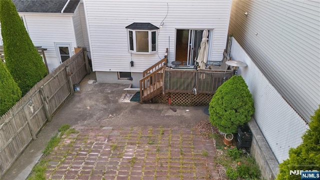 back of house featuring a patio, a wooden deck, and a fenced backyard