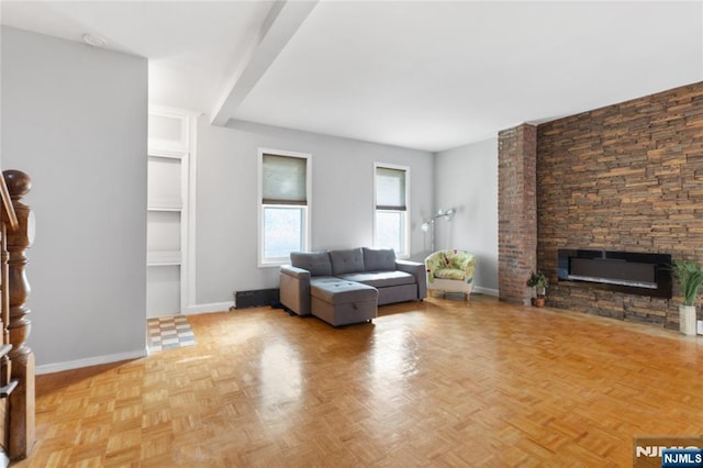living area featuring baseboards and a fireplace