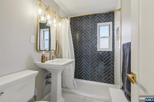 bathroom featuring a tile shower and toilet