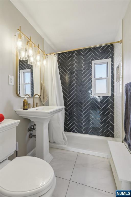 full bath featuring toilet and tiled shower
