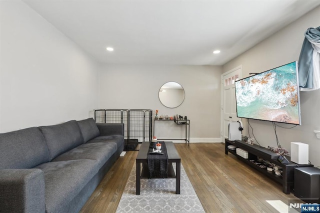 living room featuring baseboards, recessed lighting, and wood finished floors