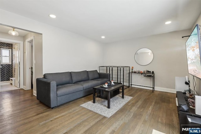 living area featuring recessed lighting, baseboards, plenty of natural light, and hardwood / wood-style floors