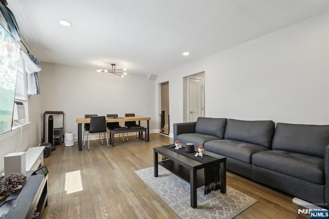 living area with recessed lighting, wood finished floors, and a notable chandelier