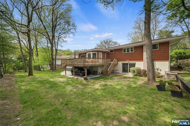 rear view of property with stairway, a yard, and a deck
