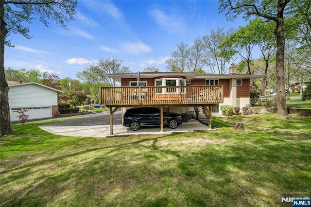 rear view of property featuring stairs, a garage, a wooden deck, a chimney, and a yard