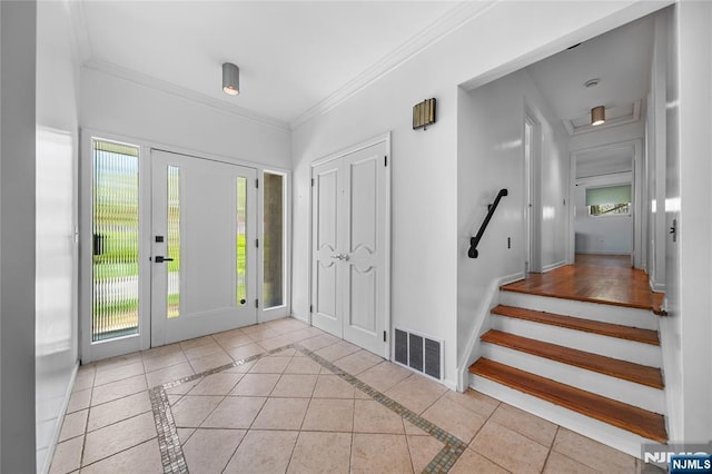 entrance foyer featuring crown molding, baseboards, visible vents, and stairs
