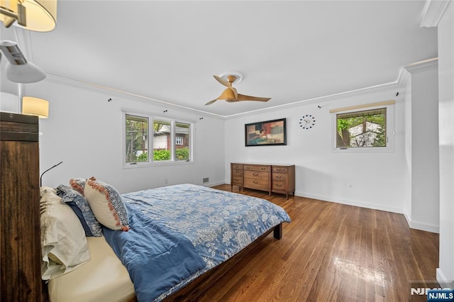 bedroom featuring crown molding, multiple windows, and wood finished floors