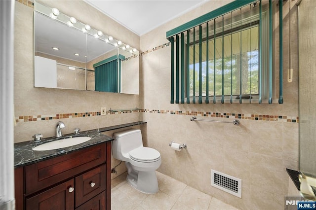 full bathroom with visible vents, tile walls, tile patterned flooring, vanity, and toilet