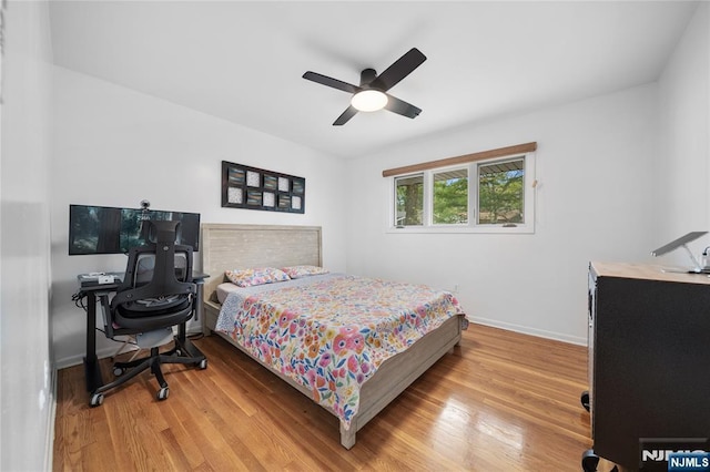 bedroom with light wood-style floors, baseboards, and a ceiling fan