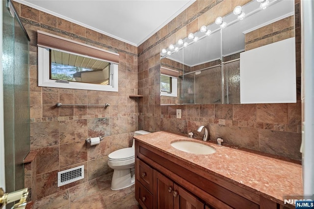 full bath with visible vents, vanity, toilet, tile walls, and a tile shower