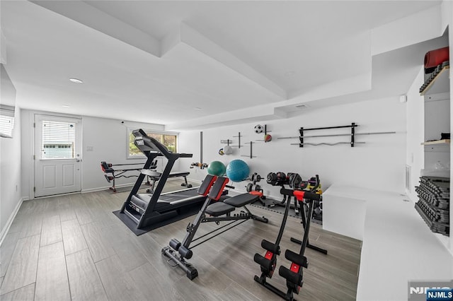 exercise room with baseboards and wood finished floors