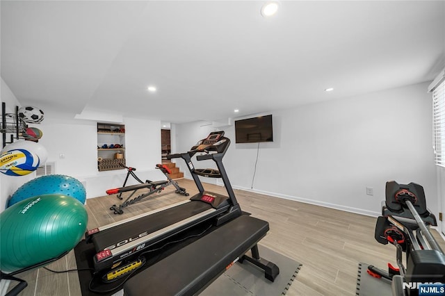 workout room featuring baseboards, recessed lighting, and wood finished floors