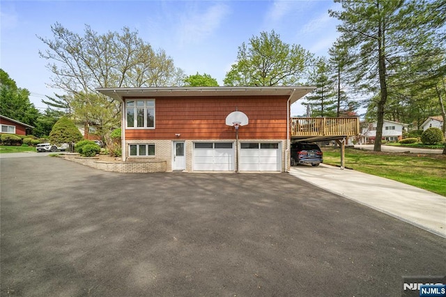 exterior space featuring a wooden deck, a carport, and aphalt driveway