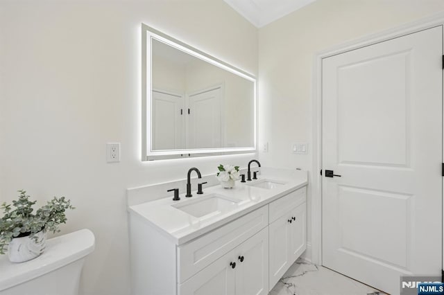 bathroom with double vanity, toilet, a sink, and marble finish floor