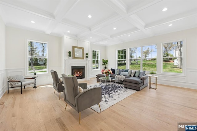 living room with coffered ceiling, light wood finished floors, beam ceiling, and a wealth of natural light