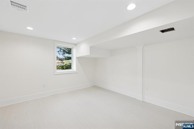 basement with baseboards, recessed lighting, and visible vents