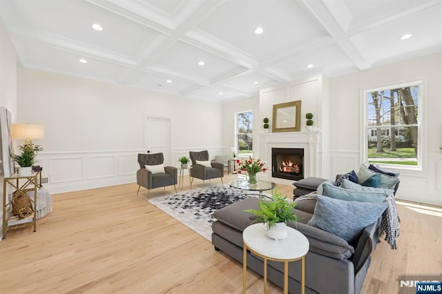 living area featuring plenty of natural light, beamed ceiling, and a decorative wall