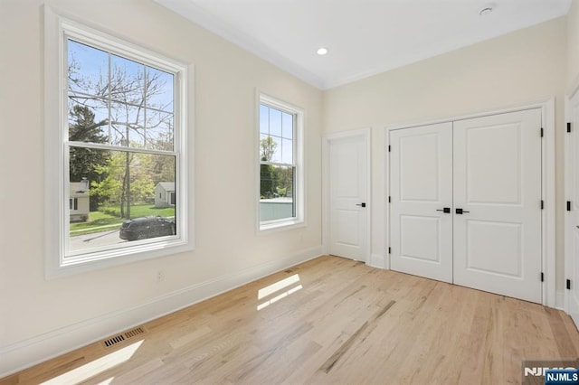 unfurnished bedroom featuring visible vents, baseboards, a closet, light wood finished floors, and recessed lighting