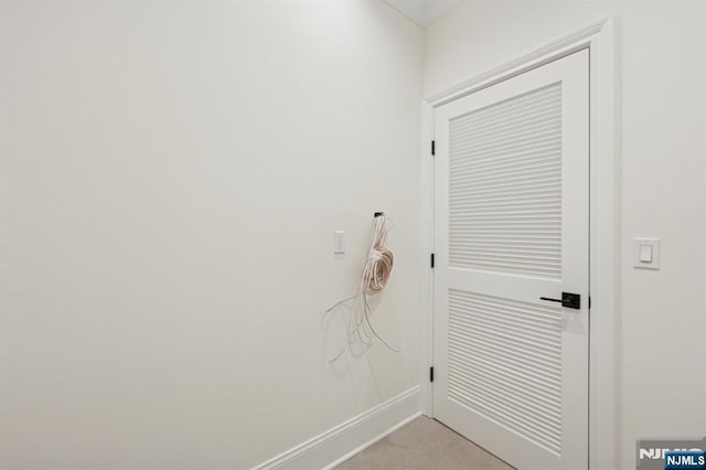 washroom featuring baseboards and light colored carpet