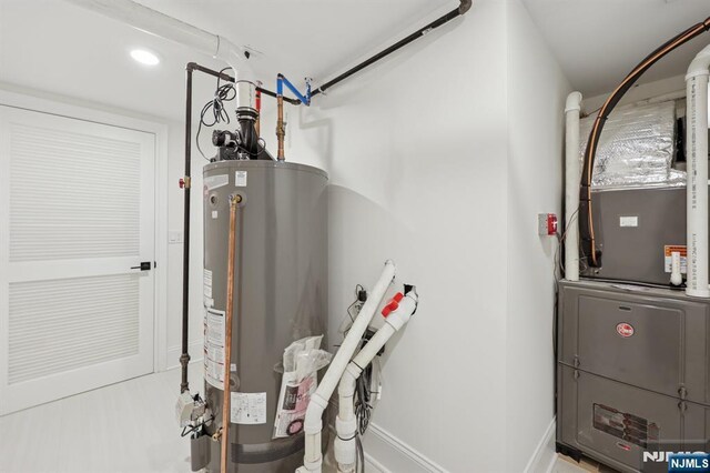 utility room with heating unit and gas water heater