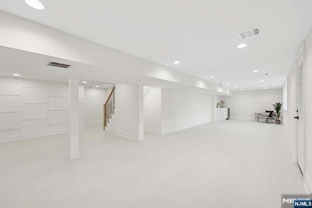 finished below grade area with stairway, baseboards, recessed lighting, and visible vents