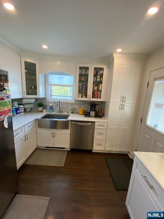 66 Lexington Ave, Rochelle Park, NJ 07662 - kitchen with a sink, stainless steel appliances, tasteful backsplash, white cabinetry, and light countertops
