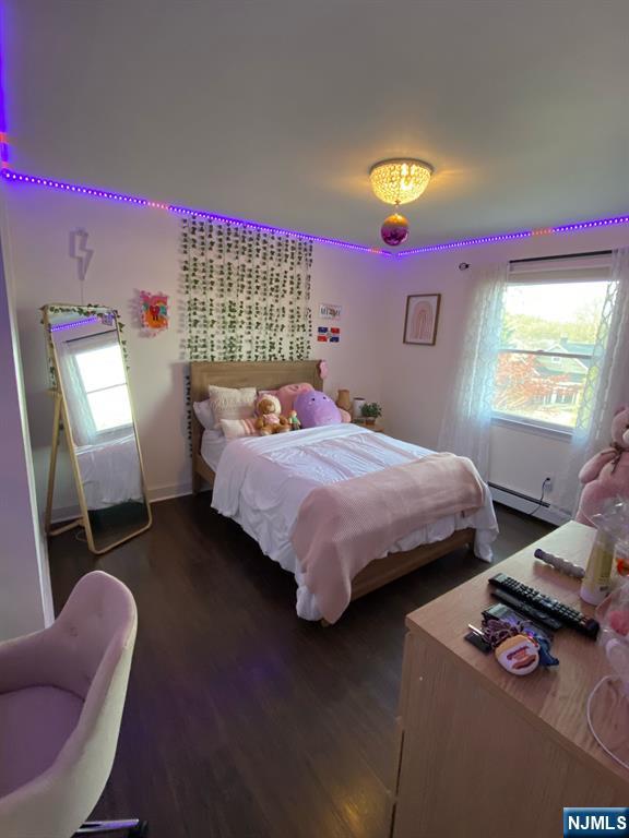 66 Lexington Ave, Rochelle Park, NJ 07662 - bedroom featuring a baseboard heating unit and dark wood-style floors