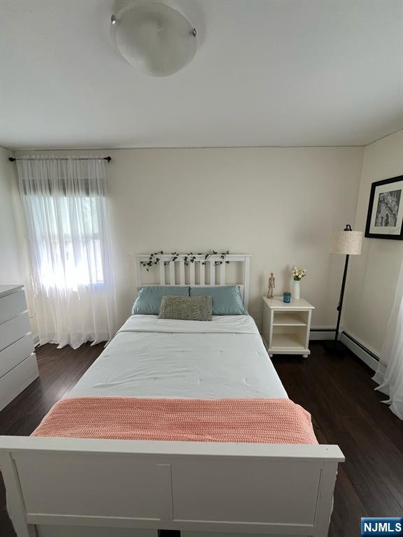 66 Lexington Ave, Rochelle Park, NJ 07662 - bedroom featuring wood finished floors and a baseboard heating unit