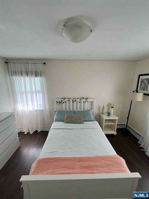 66 Lexington Ave, Rochelle Park, NJ 07662 - bedroom with a baseboard heating unit and wood finished floors