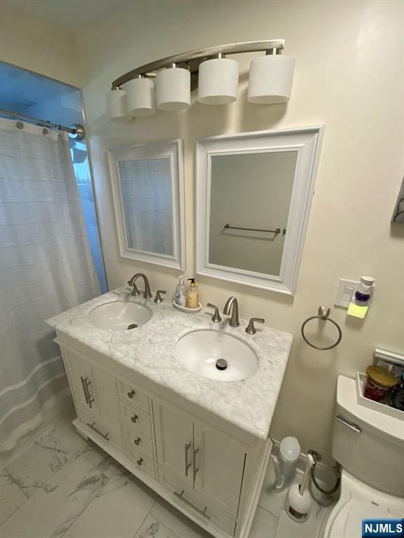 66 Lexington Ave, Rochelle Park, NJ 07662 - full bath featuring a sink, double vanity, toilet, and marble finish floor