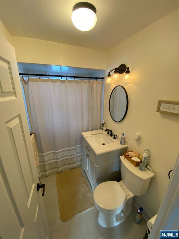66 Lexington Ave, Rochelle Park, NJ 07662 - full bathroom with vanity, toilet, a shower with curtain, and tile patterned floors