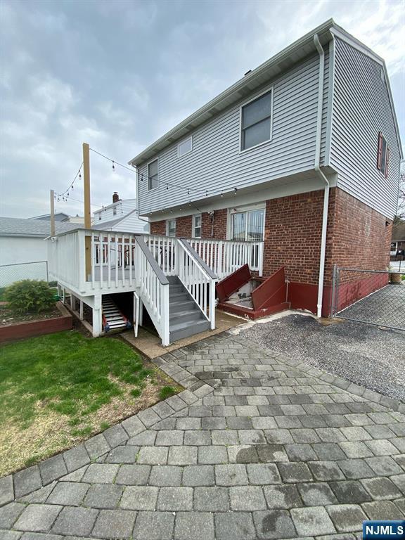 66 Lexington Ave, Rochelle Park, NJ 07662 - rear view of property with a deck, stairs, and brick siding